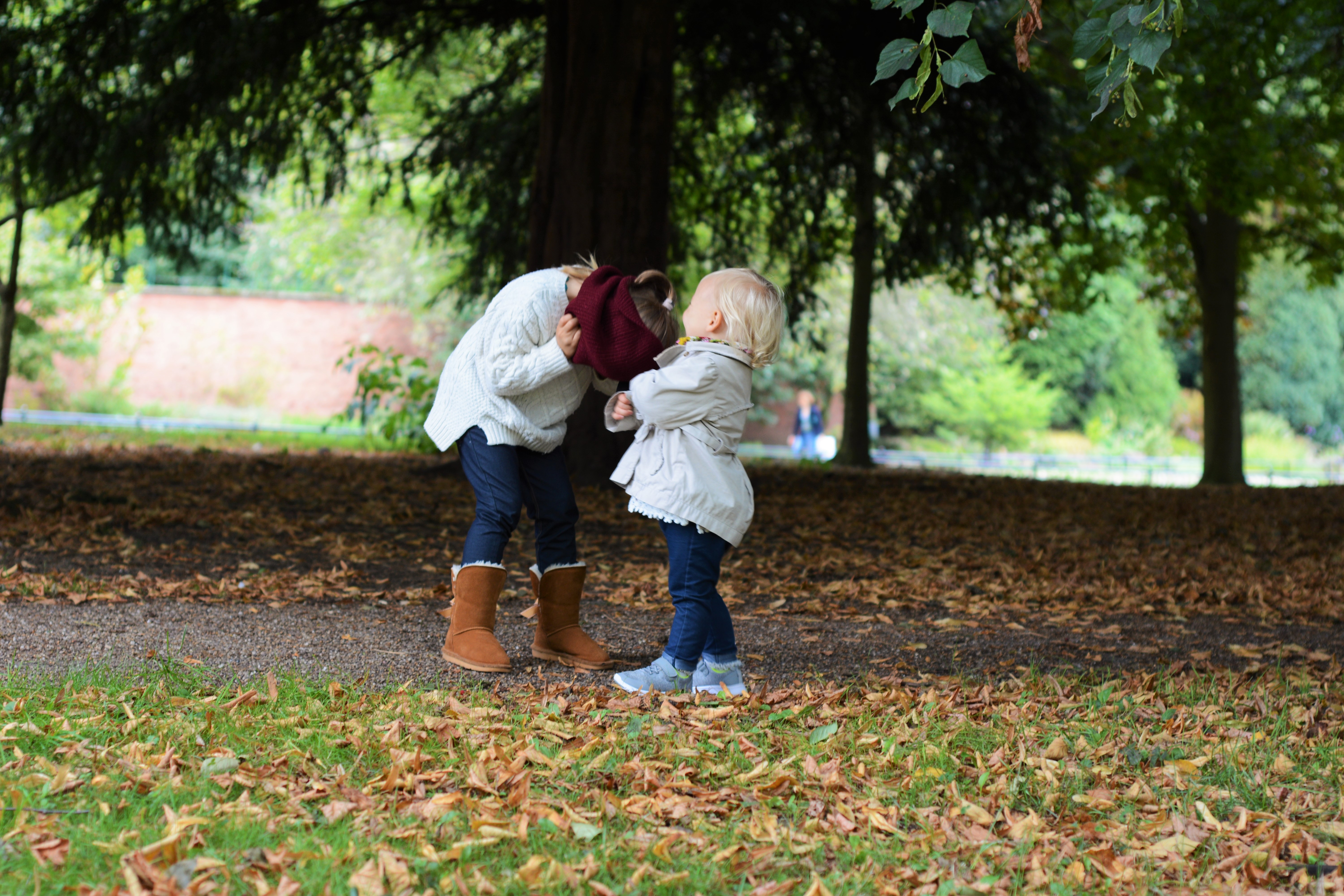 Autumn leaves and two sisters playing